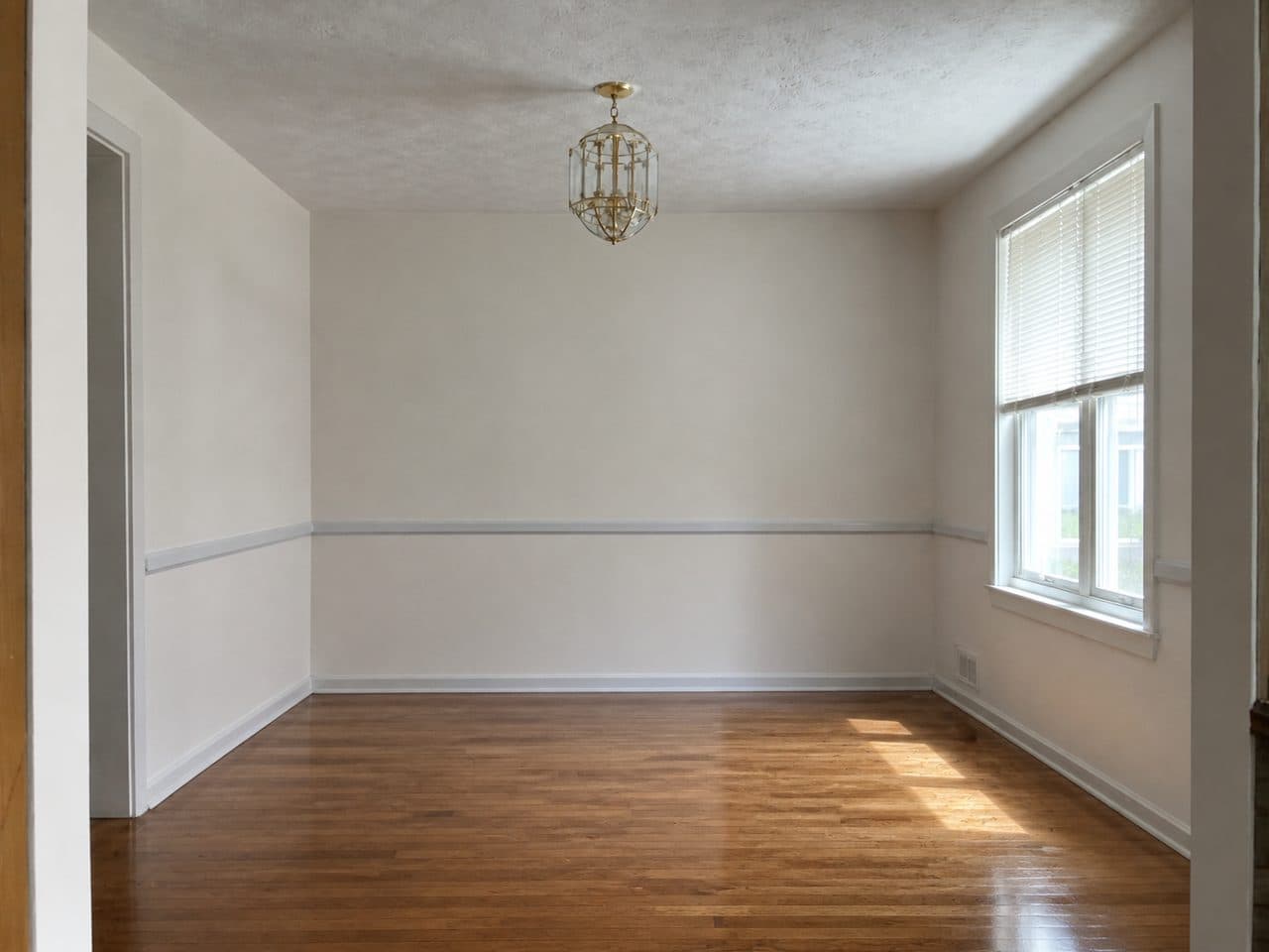 The same dining room after AI removed the furniture, keeping the walls, floor and light fixture