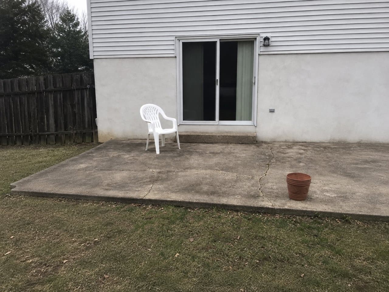 A plain, tired concrete patio before AI redesign